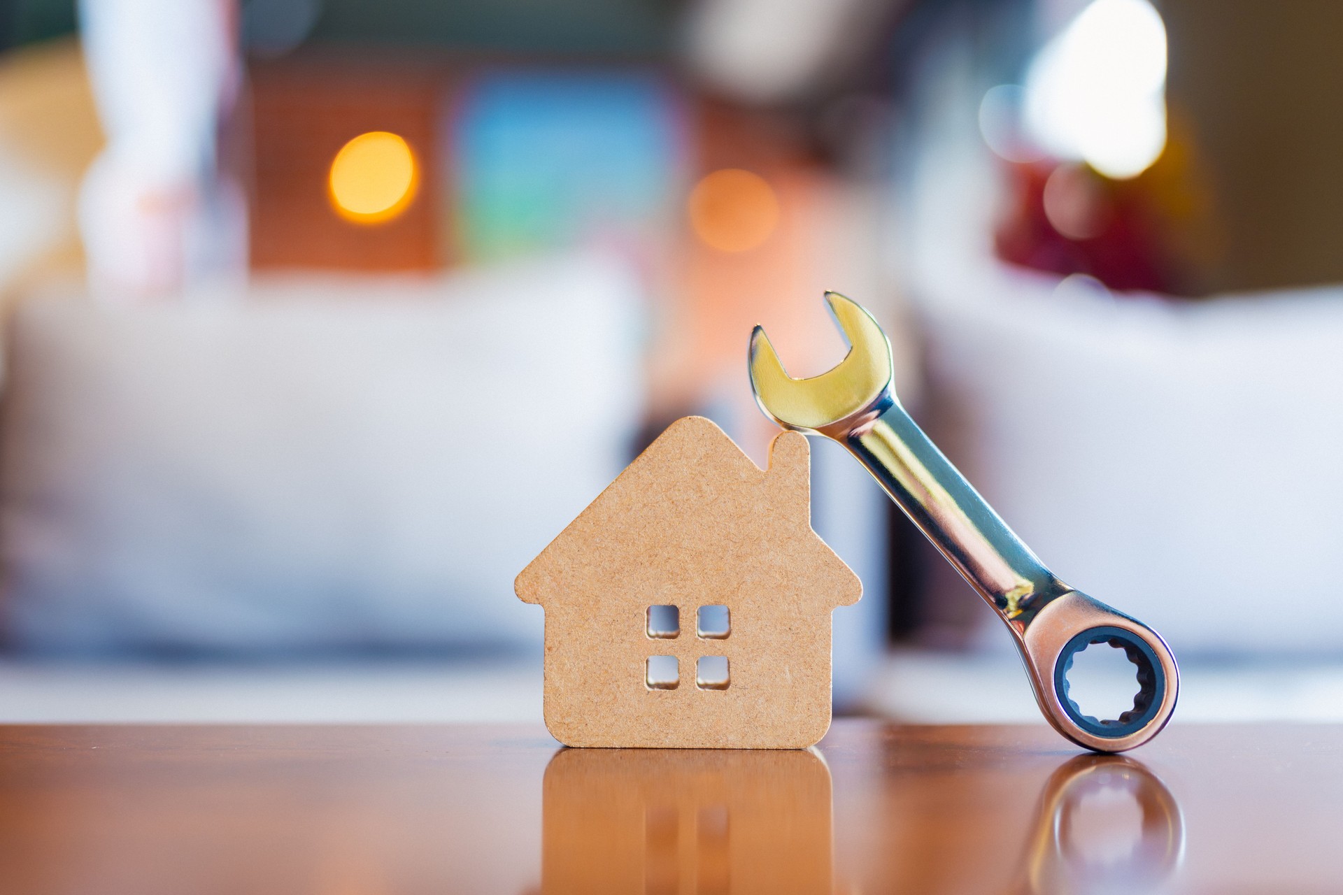 House model with metal wrench symbolizes home maintenance, repair, and real estate improvement services. Perfect for illustrating property management, renovation, and DIY concepts in business.